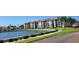 Exterior view featuring the condo building situated on well maintained grounds adjacent to a waterway at 19029 Us Highway 19 N # 8-13, Clearwater, FL 33764