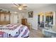 Bedroom with wood floors, a bed, a ceiling fan, and a sliding glass door to an outdoor patio at 19029 Us Highway 19 N # 9-407, Clearwater, FL 33764