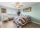 Bright bedroom with wood floors, large window, a ceiling fan, and an accent chair at 19029 Us Highway 19 N # 9-407, Clearwater, FL 33764