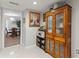 Hallway featuring tile floors, an antique hutch, and a view into the dining room at 19029 Us Highway 19 N # 9-407, Clearwater, FL 33764