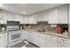 Well-lit kitchen featuring white cabinets, stainless steel sink, and granite countertops at 19029 Us Highway 19 N # 9-407, Clearwater, FL 33764