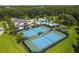 Aerial view of tennis courts, community pool, clubhouse, and surrounding greenery at 19325 Hawk Valley Dr, Tampa, FL 33647