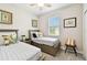 Bright bedroom with twin beds, neutral decor, and a ceiling fan at 19325 Hawk Valley Dr, Tampa, FL 33647