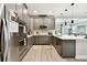 Bright kitchen features stainless steel appliances, gray cabinets, an island, and open floorplan at 19325 Hawk Valley Dr, Tampa, FL 33647