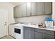 Laundry room with gray cabinets, sink, and modern washer and dryer at 19325 Hawk Valley Dr, Tampa, FL 33647