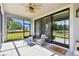Covered outdoor patio with ceiling fan, comfortable seating, and sliding glass doors to the backyard at 19325 Hawk Valley Dr, Tampa, FL 33647