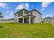 Expansive backyard with a covered patio, seating area and lush green lawn at 19719 Cypress Bridge Dr, Odessa, FL 33556