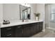 Bathroom with a long vanity, white countertops, a mirror and natural light from the window at 19719 Cypress Bridge Dr, Odessa, FL 33556