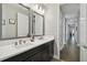 Stylish bathroom featuring a double sink vanity, modern lighting, and contemporary mirrors at 19719 Cypress Bridge Dr, Odessa, FL 33556