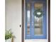 Stylish blue front door with glass panels and a welcoming decorative wreath at 19719 Cypress Bridge Dr, Odessa, FL 33556