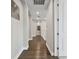 Hallway with rich hardwood floors, neutral walls, arched doorways and white trim at 19719 Cypress Bridge Dr, Odessa, FL 33556