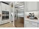 Modern stainless steel refrigerator and coffee machine integrated into the kitchen, with white cabinets at 19719 Cypress Bridge Dr, Odessa, FL 33556