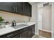 Laundry room featuring dark cabinets, white countertops, and modern fixtures at 19719 Cypress Bridge Dr, Odessa, FL 33556