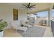 Relaxing covered patio features lounge chairs, a ceiling fan, and neighborhood views at 19719 Cypress Bridge Dr, Odessa, FL 33556