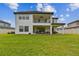 Rear of home showcasing a covered patio, balcony, spacious lawn, and upscale outdoor furniture at 19719 Cypress Bridge Dr, Odessa, FL 33556
