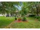 Lush, green backyard with a covered patio and mature trees providing shade at 20749 Auburn Leaf Trl, Land O Lakes, FL 34638