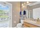 Bright bathroom featuring a wood vanity, neutral walls, and a glass shower door at 20749 Auburn Leaf Trl, Land O Lakes, FL 34638
