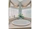 Close-up on a large soaking tub with tile surround and decorative drapes at 20749 Auburn Leaf Trl, Land O Lakes, FL 34638