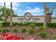 The 'Lake Talia' deed-restricted community entrance sign is surrounded by vibrant flowerbeds and greenery at 20749 Auburn Leaf Trl, Land O Lakes, FL 34638