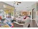 Open-concept living room flowing into the kitchen and patio, featuring a modern sofa and colorful rug at 20749 Auburn Leaf Trl, Land O Lakes, FL 34638