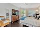 Comfortable main bedroom with dark wood floors, a TV, and access to the backyard at 20749 Auburn Leaf Trl, Land O Lakes, FL 34638