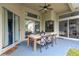 Covered patio with ceiling fan and a wooden table with seating for six at 20749 Auburn Leaf Trl, Land O Lakes, FL 34638
