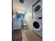 Bathroom featuring a stacked washer and dryer, a modern vanity, a toilet, and tile flooring at 2333 Feather Sound Dr # B511, Clearwater, FL 33762