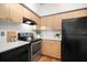 Bright kitchen featuring stainless steel appliances, wood cabinets, and sleek white countertops at 2410 W Azeele St # 228, Tampa, FL 33609