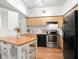 Well-lit kitchen featuring stainless steel appliances, light wood cabinets, and hardwood floors at 2410 W Azeele St # 228, Tampa, FL 33609