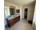 Bathroom featuring double sinks, granite counters, and walk-in closet access at 26357 Trinilas Dr, Punta Gorda, FL 33983