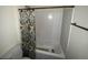 Standard tub/shower combo with patterned shower curtain and simple white wall tile at 26357 Trinilas Dr, Punta Gorda, FL 33983