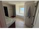 Well-lit bathroom featuring a soaking tub, walk-in closet, and tiled flooring at 26357 Trinilas Dr, Punta Gorda, FL 33983