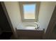 Close-up of the white soaking tub beneath a window in the bathroom at 26357 Trinilas Dr, Punta Gorda, FL 33983