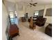 Open concept living room with neutral tile flooring, a ceiling fan, and leather furniture at 26357 Trinilas Dr, Punta Gorda, FL 33983