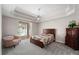 Cozy main bedroom featuring a tray ceiling, ceiling fan, and access to the pool at 2803 Bent Leaf Dr, Valrico, FL 33594