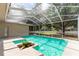 A screened pool surrounded by lush trees and green grass at 2803 Bent Leaf Dr, Valrico, FL 33594