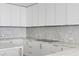 Close up of kitchen area with marble backsplash and countertops and sleek appliances at 2912 W Santiago St # 1401, Tampa, FL 33629