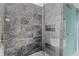 Gray marble shower with a glass door and built in shelving for storage at 2912 W Santiago St # 1401, Tampa, FL 33629