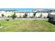 Backyard features a lush lawn, a garden bed along the back fence and a garden bed in foreground at 32313 Conchshell Sail St, Wesley Chapel, FL 33545