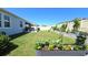 Wide angle view of backyard with garden beds, a screened-in porch and a lawn at 32313 Conchshell Sail St, Wesley Chapel, FL 33545