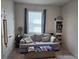 Cozy bedroom featuring a comfortable couch, window with blinds and a bookshelf at 32313 Conchshell Sail St, Wesley Chapel, FL 33545