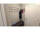 Inviting entryway featuring a coat rack, storage bench, and a 'Home Sweet Home' sign at 32313 Conchshell Sail St, Wesley Chapel, FL 33545