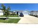 Charming single-story home featuring a well-manicured lawn, stone accents, and a two-car garage at 32313 Conchshell Sail St, Wesley Chapel, FL 33545