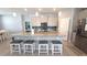Bright kitchen features a large island with seating, granite countertops, and stainless steel appliances at 32313 Conchshell Sail St, Wesley Chapel, FL 33545
