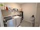 Functional laundry room with washer, dryer, sink, and storage shelves for supplies at 32313 Conchshell Sail St, Wesley Chapel, FL 33545