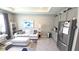 Open concept living room and kitchenette with stainless steel appliances and modern decor at 32313 Conchshell Sail St, Wesley Chapel, FL 33545