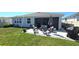 Backyard featuring a screened-in patio with seating, a lawn and garden bed at 32313 Conchshell Sail St, Wesley Chapel, FL 33545