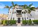 Modern three-story home featuring palm trees, a balcony, and a well-maintained front yard with stone details at 325 2Nd N St, St Petersburg, FL 33701