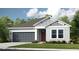 Charming single-story home with a gray two-car garage and a well-manicured lawn at 3408 Lumber Falls Dr, Plant City, FL 33565
