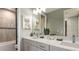 Modern bathroom with double sinks, tile backsplash, framed mirrors, and a shower/tub combo at 3415 Lumber Falls Dr, Plant City, FL 33565